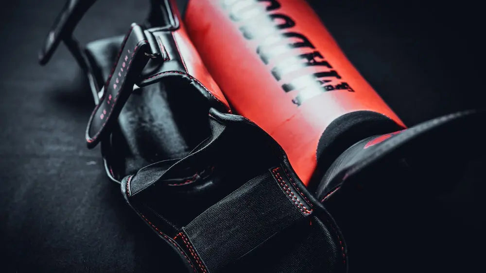 Hochwertige Schienbeinschoner für Kickboxen liegen bereit für das Training in einem Boxgym – MADGON Schutzausrüstung